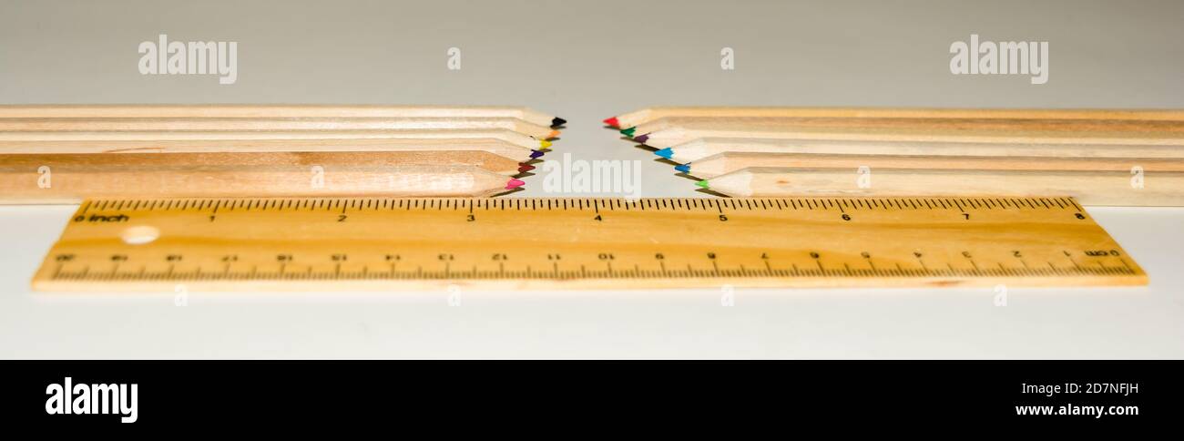 Couleur crayon en forme d'hexagone et règle en bois sur fond blanc. Banque D'Images