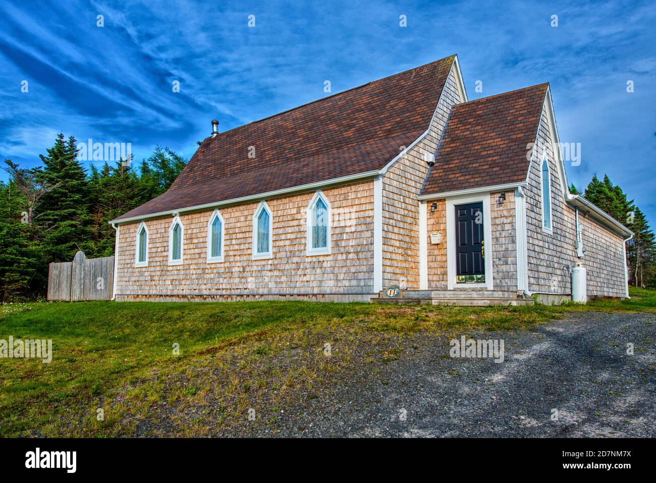 Une église d'époque récemment rénovée avec parement à shake en cèdre, bardeaux de toit marron et cinq fenêtres en verre clair à stéeple clerestory. Banque D'Images