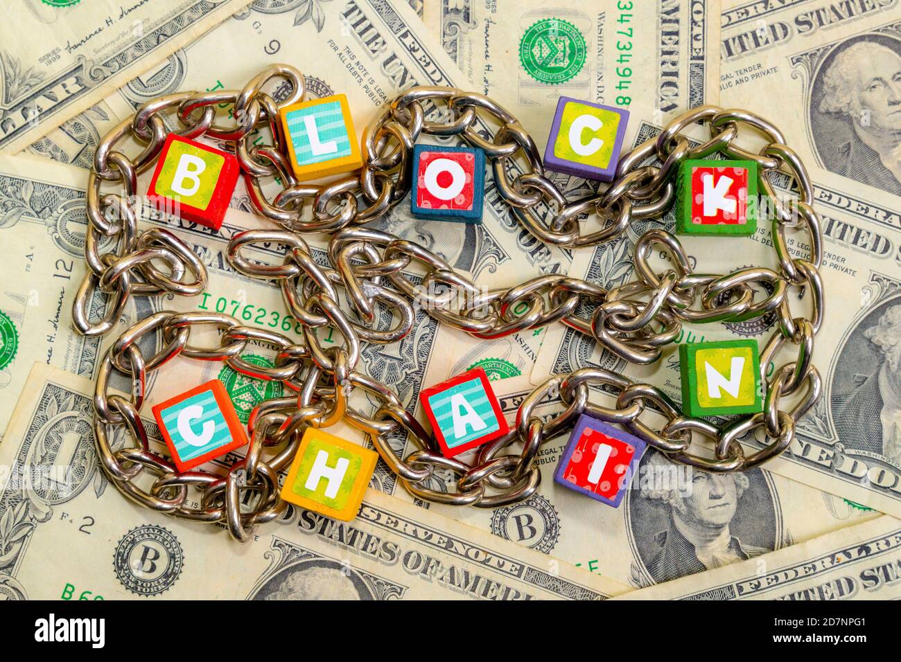 Les petits blocs de couleur sont en majuscules. Une chaîne serpente autour d'eux. Tout repose sur les billets américains. Vue de dessus. Banque D'Images