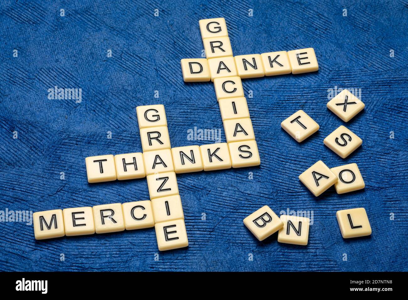merci dans différentes langues mots croisés en ivoire lettre tuiles contre papier texturé, concept de communication Banque D'Images