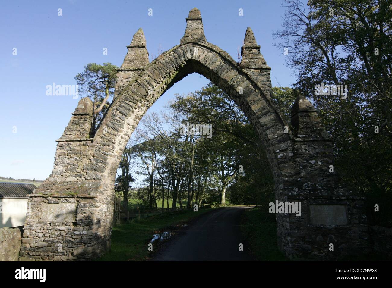 Frontières , Écosse, Royaume-Uni Spottiswoode Arches. « Spottiswood House était de style Jacobeque, immense, et construite en 1832-4 par l'architecte William Burn. Les arches Gothick de Pyatshaw et Bruntaburn faisaient partie de ses politiques et de son paysage. Ruben Gothick Arch enjambant la route vers SW de l'ancienne maison Spottiswoode (démolie). Couronné de 2 niveaux de pinnacles; plaques (sculptées, bien altérées et illisibles) aux pières bordées. Banque D'Images