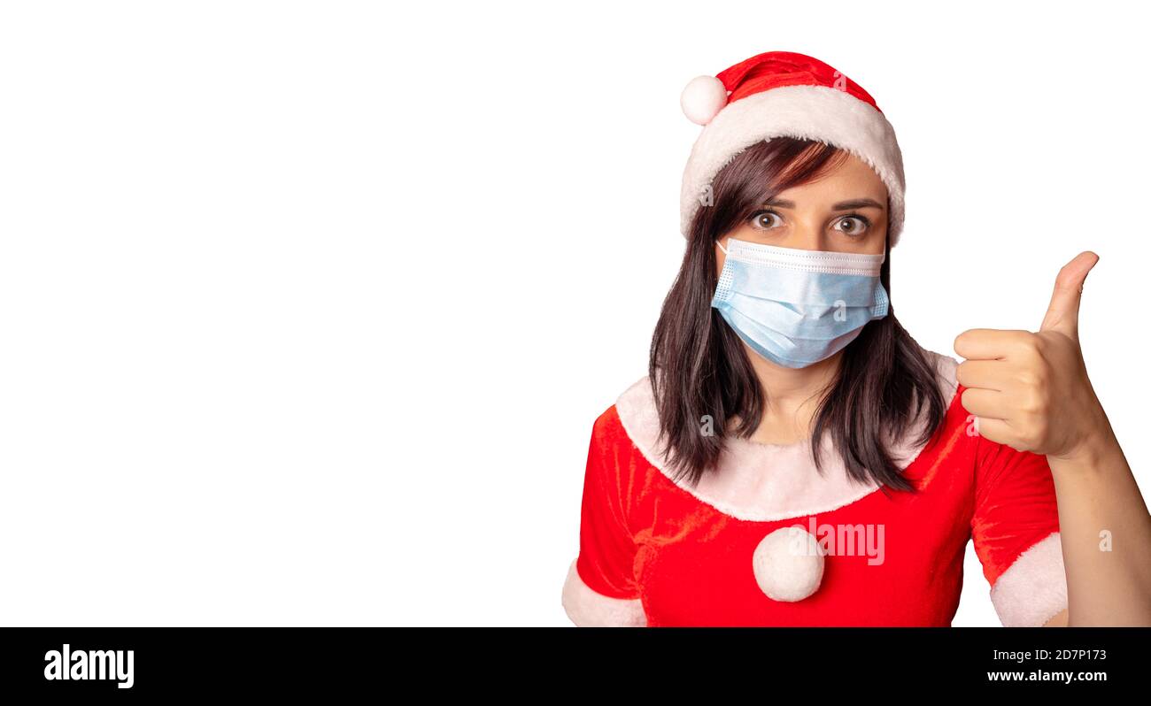 La jeune femme en costume du Père Noël montre les pouces sur fond blanc. Gros plan d'une femme dans un chapeau de Noël montrant un geste d'approbation. Concept de Banque D'Images