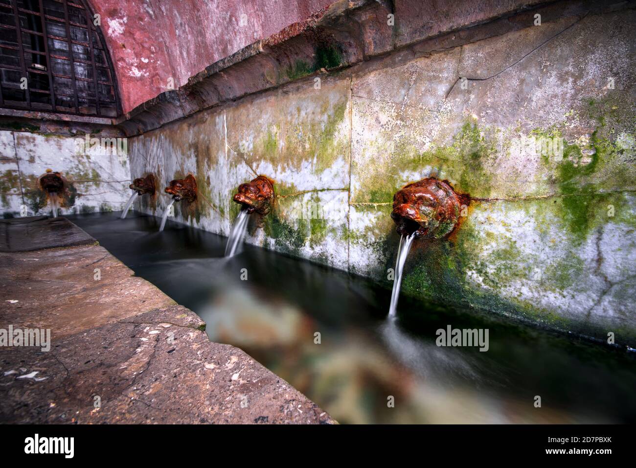 Bouches en fonte à Lavatoio Medievale, lavoir médiévale. Cefalù, Sicile, Italie. Banque D'Images