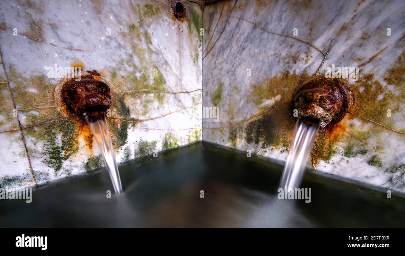 Bouches en fonte à Lavatoio Medievale, lavoir médiévale. Cefalù, Sicile, Italie. Banque D'Images