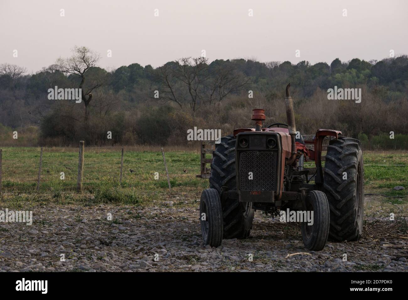 Gros plan d'un vieux tracteur rouillé au milieu du champ un jour sombre Banque D'Images