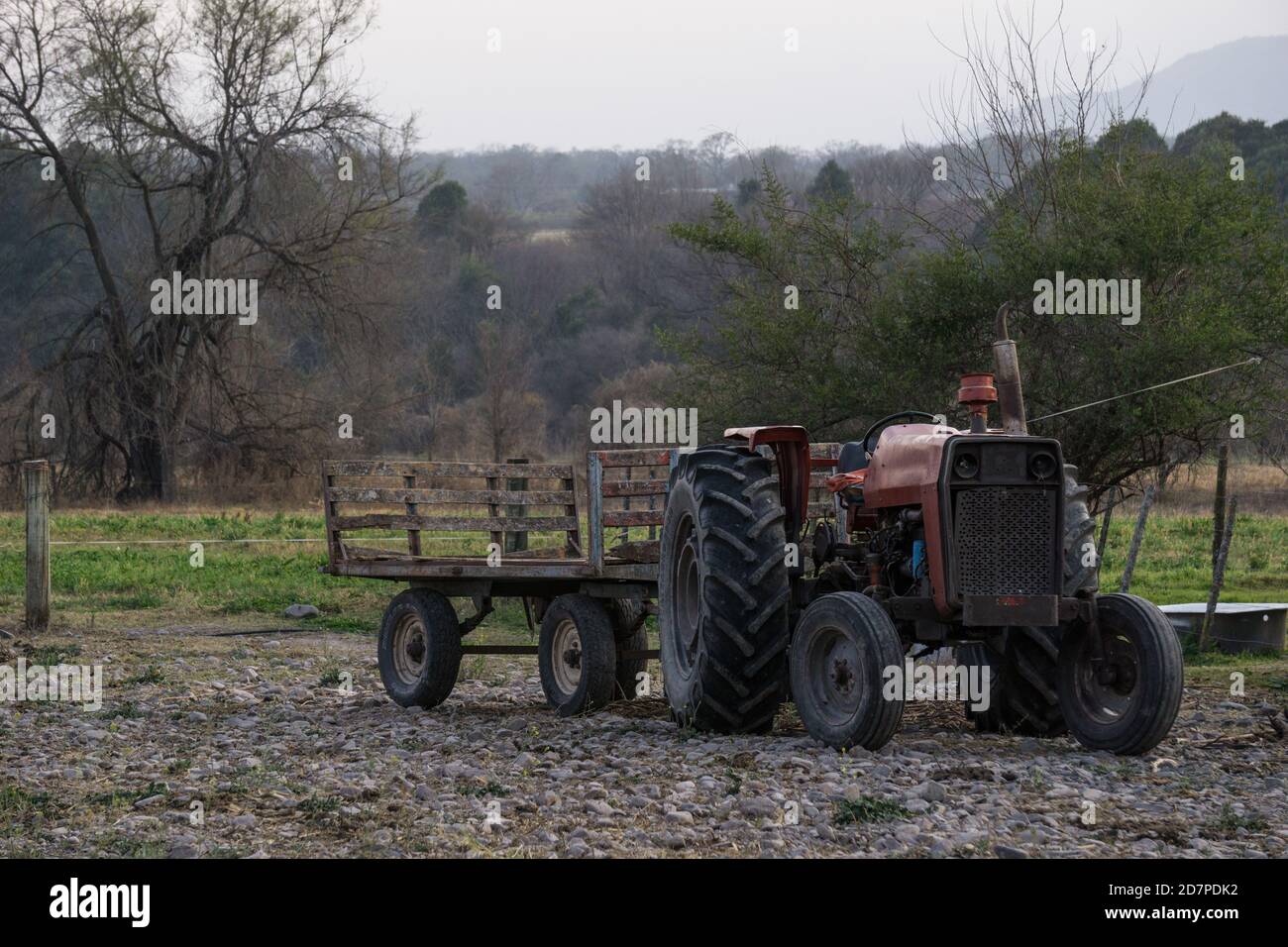 Gros plan d'un vieux tracteur rouillé au milieu d'un champ un jour sombre Banque D'Images