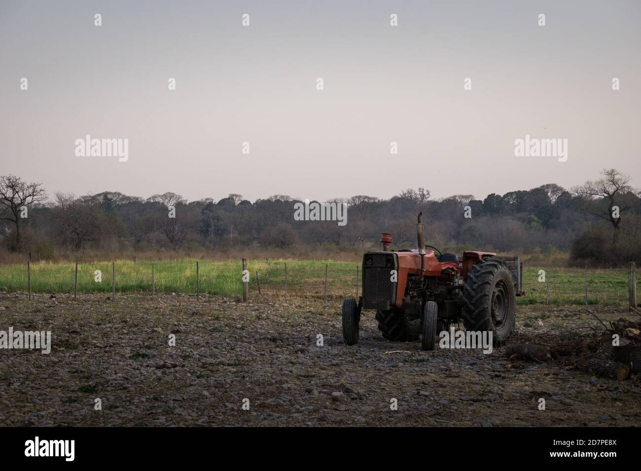 Tracteur ancien et rouillé au milieu du champ un jour sombre Banque D'Images