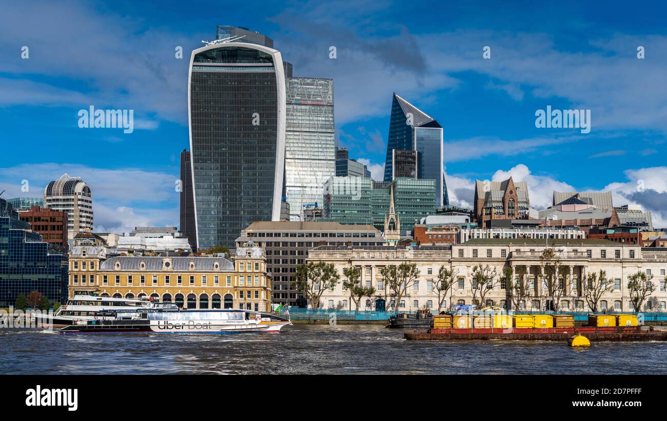 Vue sur la rivière de la ville de Londres - la barge de déchets et le River bus de marque UBER passent devant le bâtiment Walkie Talkie et le quartier financier de la ville de Londres. Banque D'Images