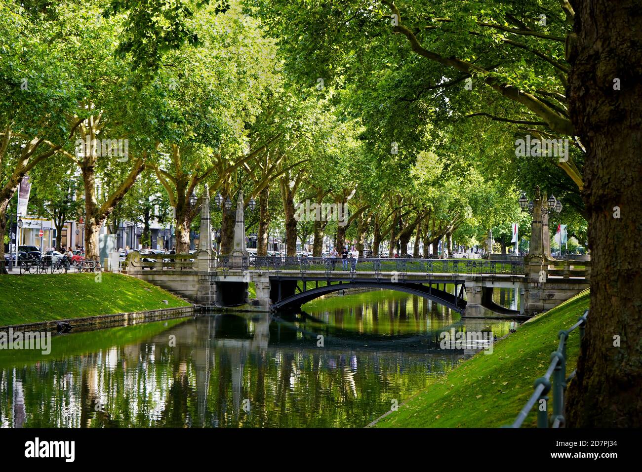 Le magnifique canal historique de la ville 'Kö-Graben' sur la Königsallee à Düsseldorf avec de vieux arbres et ponts. Banque D'Images