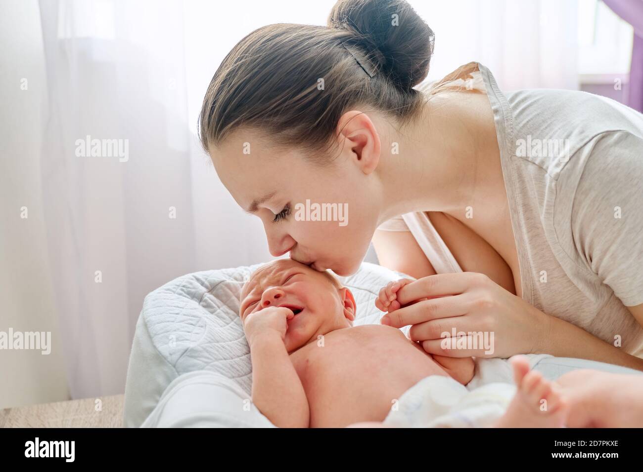 Jeune maman embrassant nouveau-né bébé fils Banque D'Images