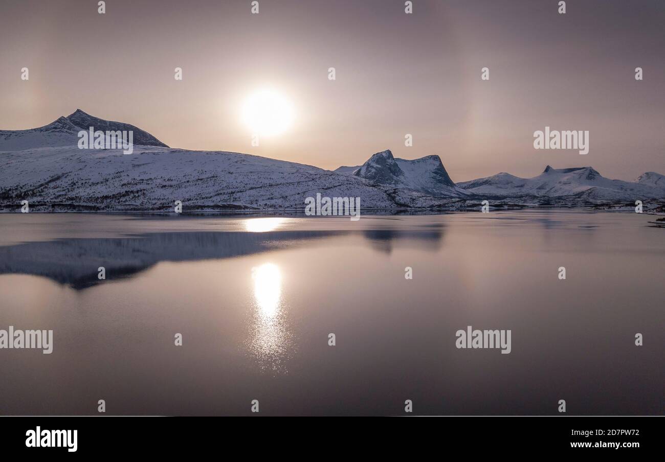 Anneau de soleil, halo sur la chaîne de montagne enneigée, paysage d'hiver arctique, en front de mer, ballangen, Nordland, Norvège Banque D'Images