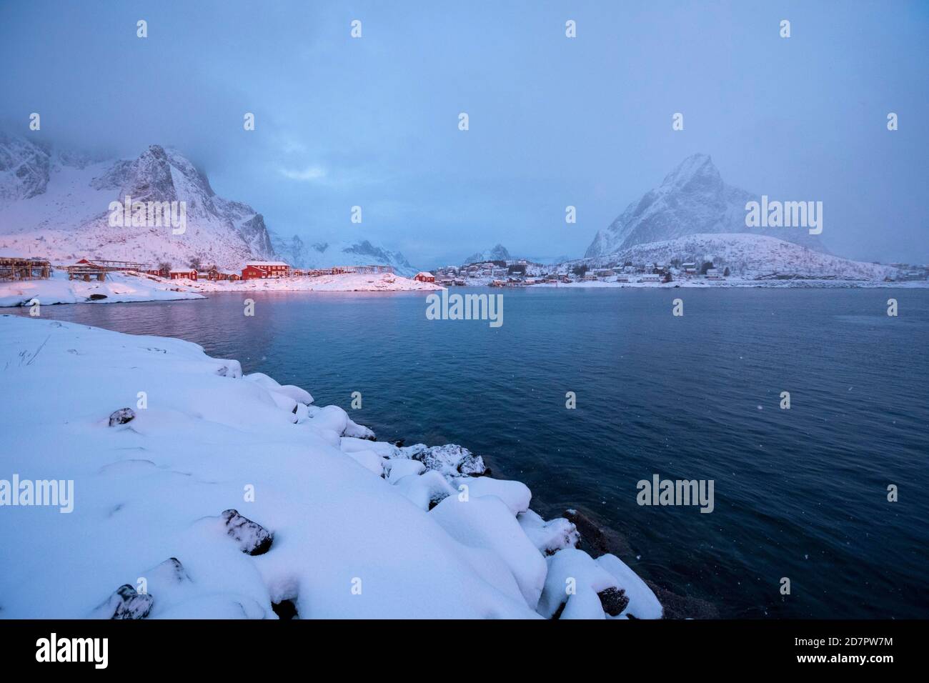 Atmosphère d'hiver sur le fjord, tôt le matin dans le village de pêcheurs, chute de neige dans les montagnes, Reine, Nordland, Lofoten, Norvège Banque D'Images