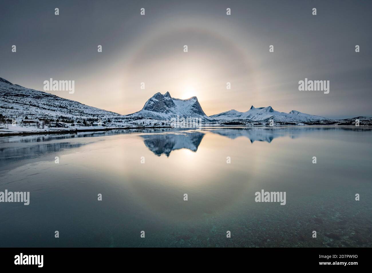 Anneau de soleil, halo sur la chaîne de montagnes enneigée Kulhornet, paysage d'hiver arctique, Kobbenestinden, en front de mer, Ballangen, Nordland, Norvège Banque D'Images