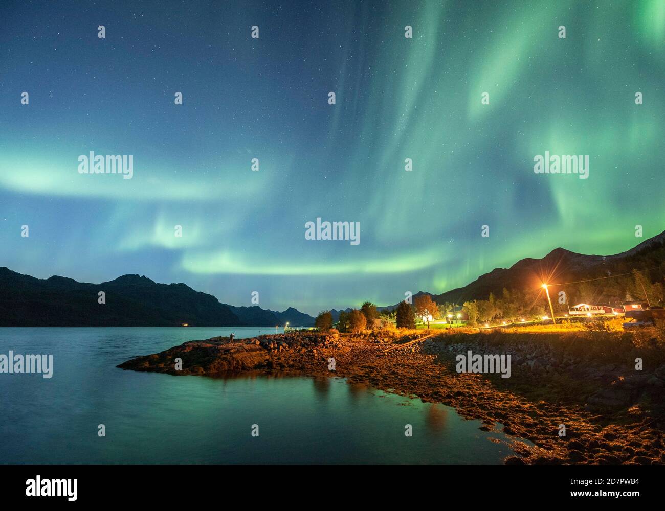 Aurora borealis aux maisons illuminées du fjord, Skutvik, Nordland, Norvège Banque D'Images