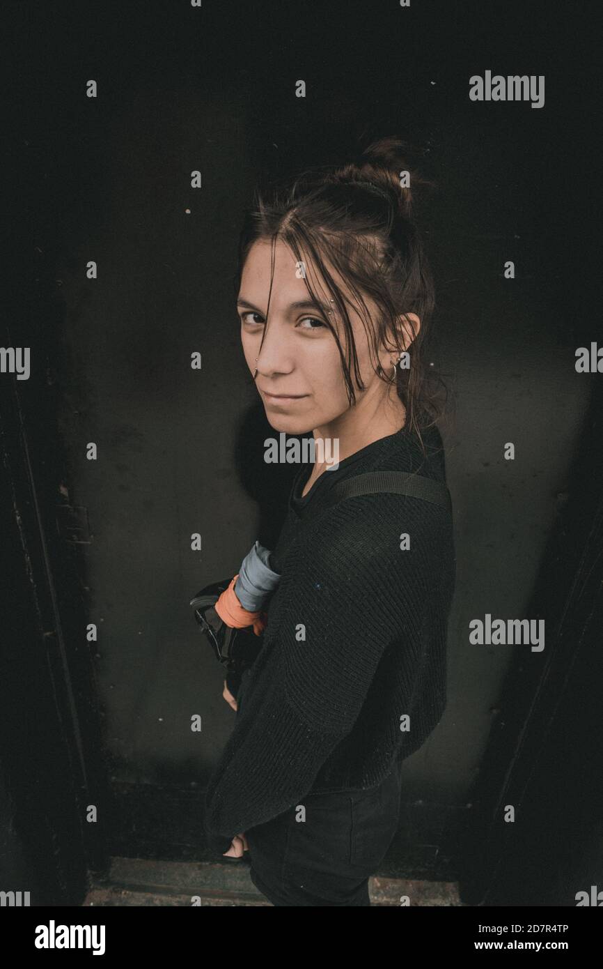 Portrait vertical à grand angle d'une femme décontractée malheureux posant dans une rue et regardant la caméra Banque D'Images
