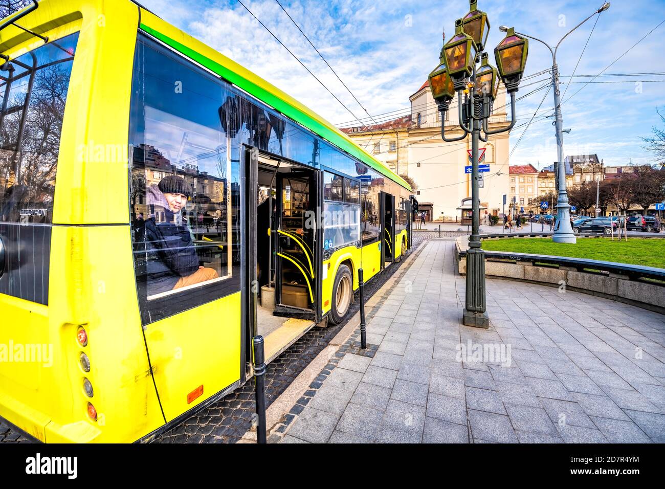Lviv, Ukraine - 21 janvier 2020: Ukrainian Lvov ville vieille ville avec jaune arrêt de bus de transport public avec les gens homme assis à l'intérieur regardant l'Allemagne Banque D'Images