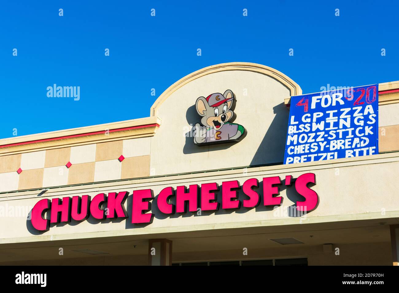 Le logo Chuck E. Cheese et l'affiche publicitaire de la femme de ménage choisissent 4 articles pour 20 dollars au-dessus de l'entrée du centre de divertissement familial et du restaurant - C Banque D'Images