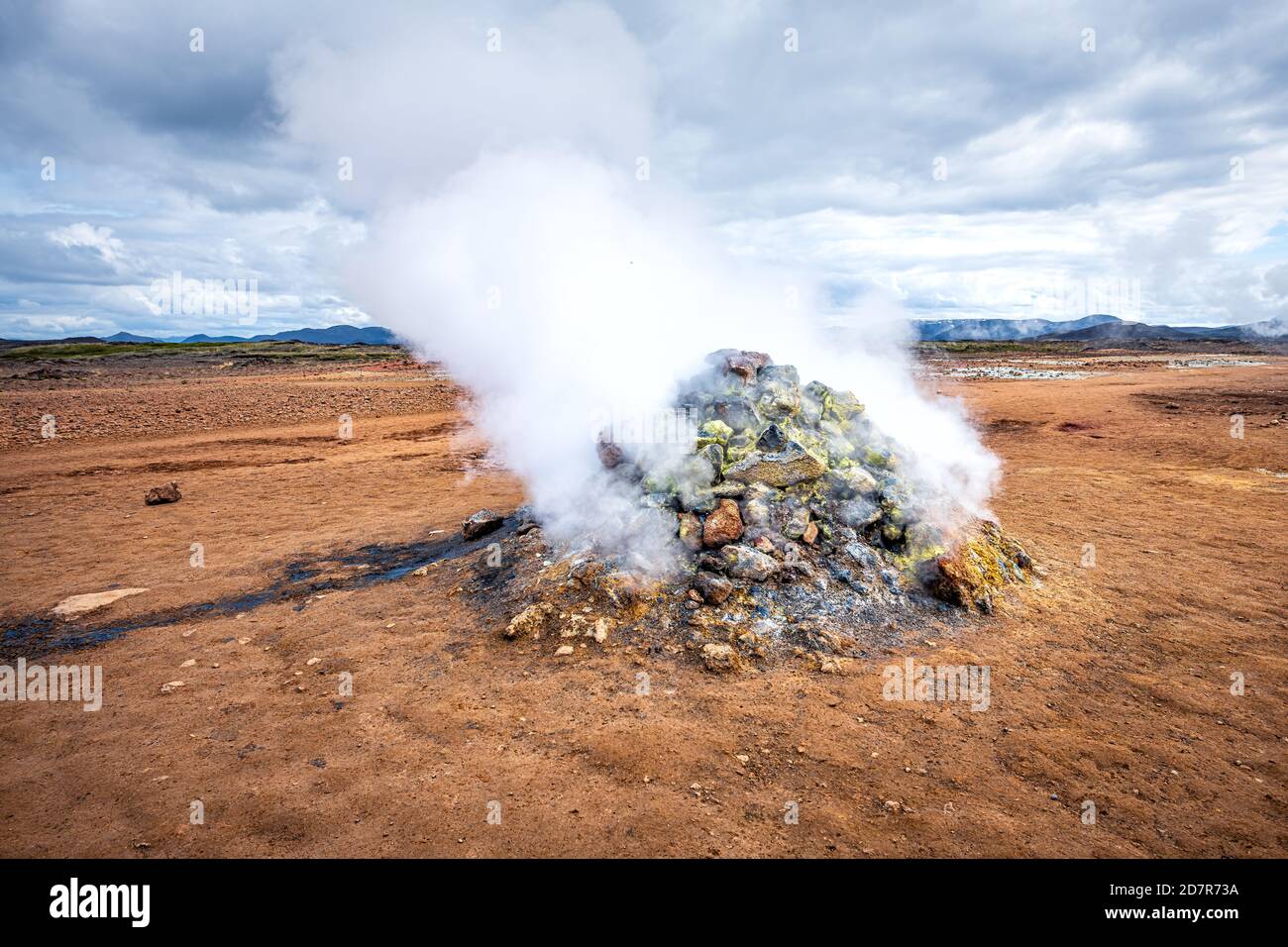 Vapeur chaude s'élevant de la pile de roches geyser à Hverir Zone géothermique en Islande par Myvatn caldera lac célèbre Place dans le nord de l'Islande Banque D'Images