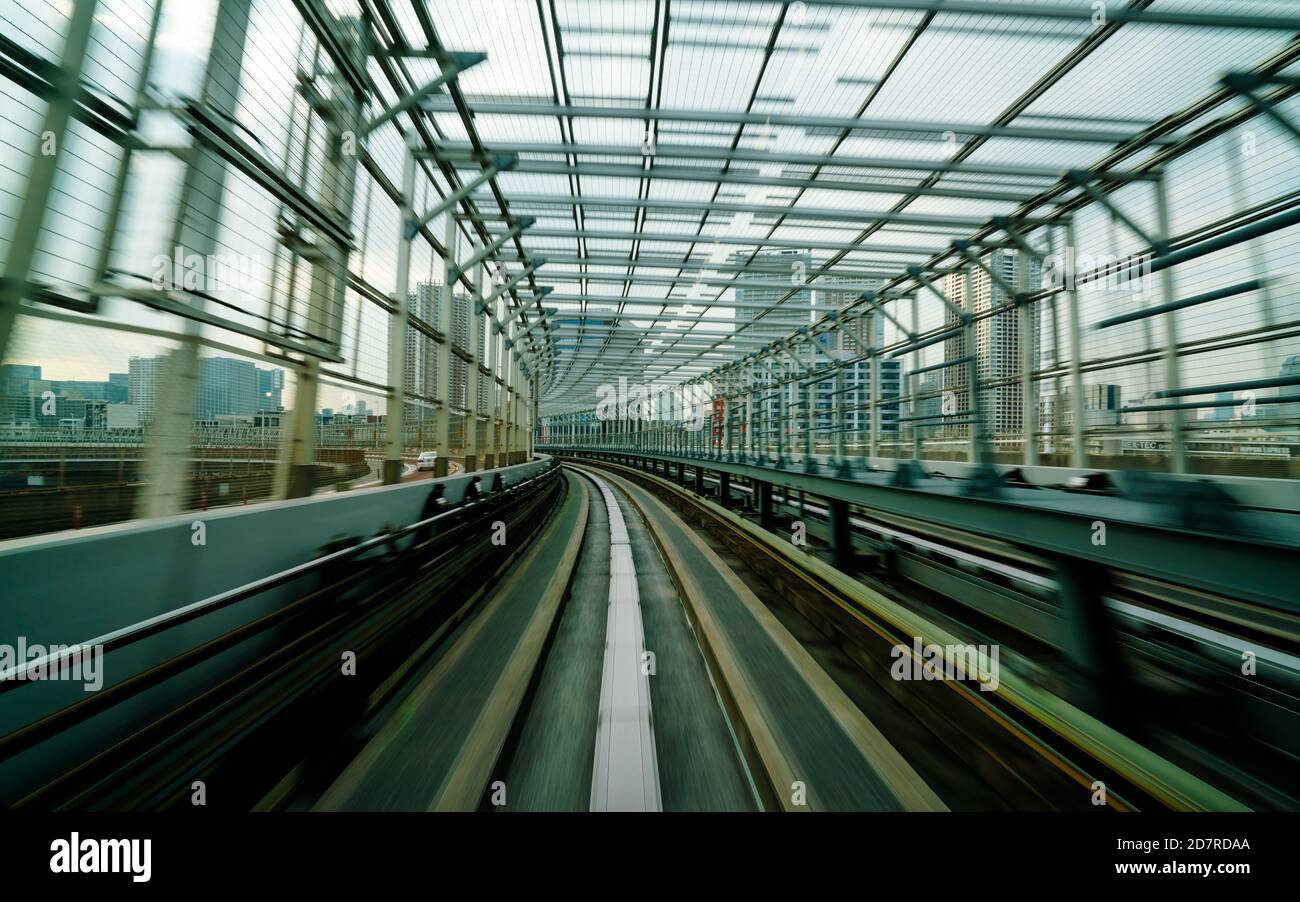 Vue de face du train en mouvement dans le tunnel ferroviaire de la ville avec un effet de flou modéré et un filtre vintage. Concept de transport et arrière-plan flou de mouvement Banque D'Images