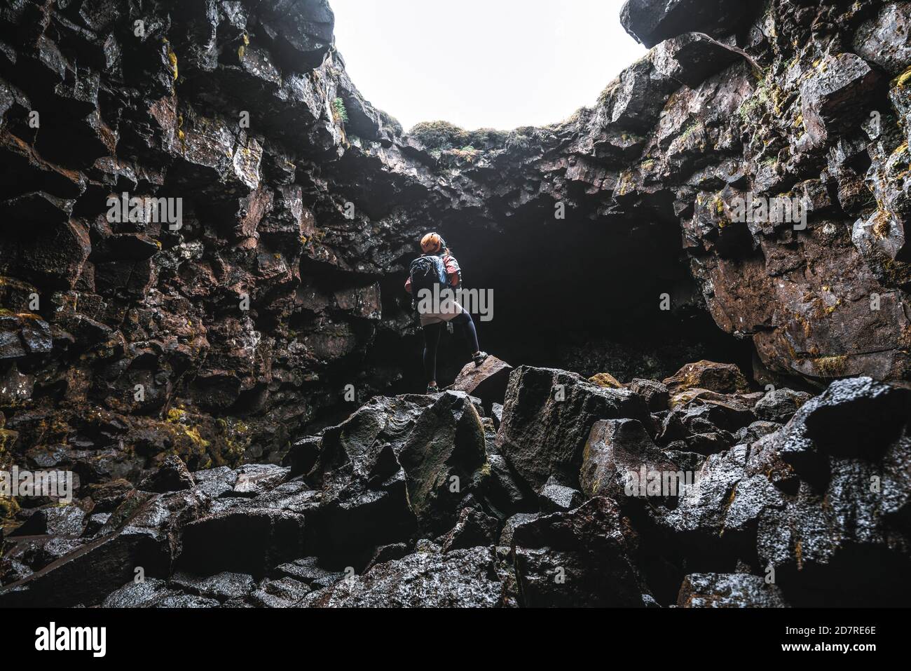 Une femme voyageur explore le tunnel de lave en Islande. Raufarholshellir est un beau monde caché de caverne. C'est l'une des plus longues et des plus connues lave Banque D'Images