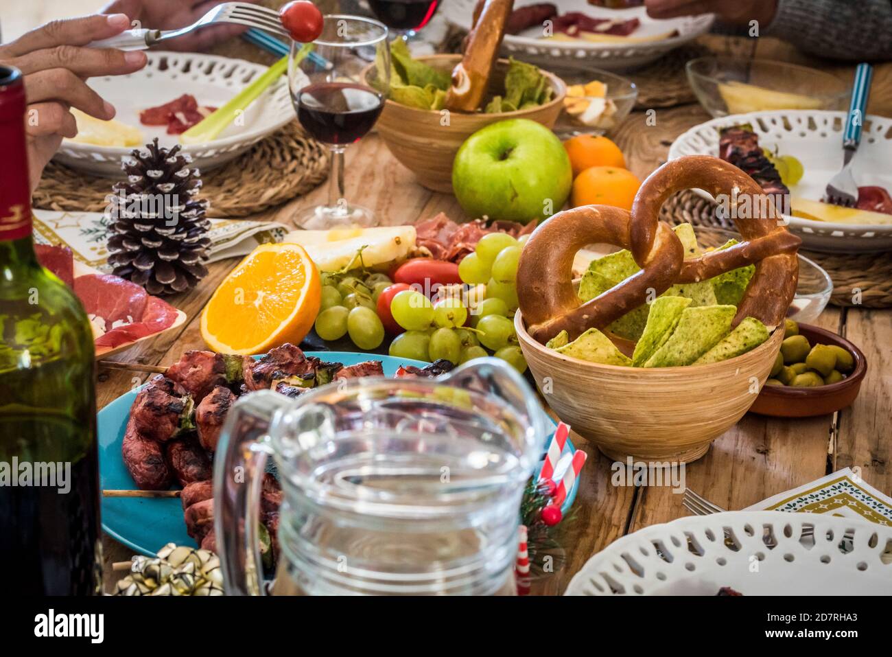 Gros plan de la décoration d'hiver la table de la veille de noël pleine de la nourriture et les gens qui apprécient la fête - concept traditionnel et de célébration Banque D'Images