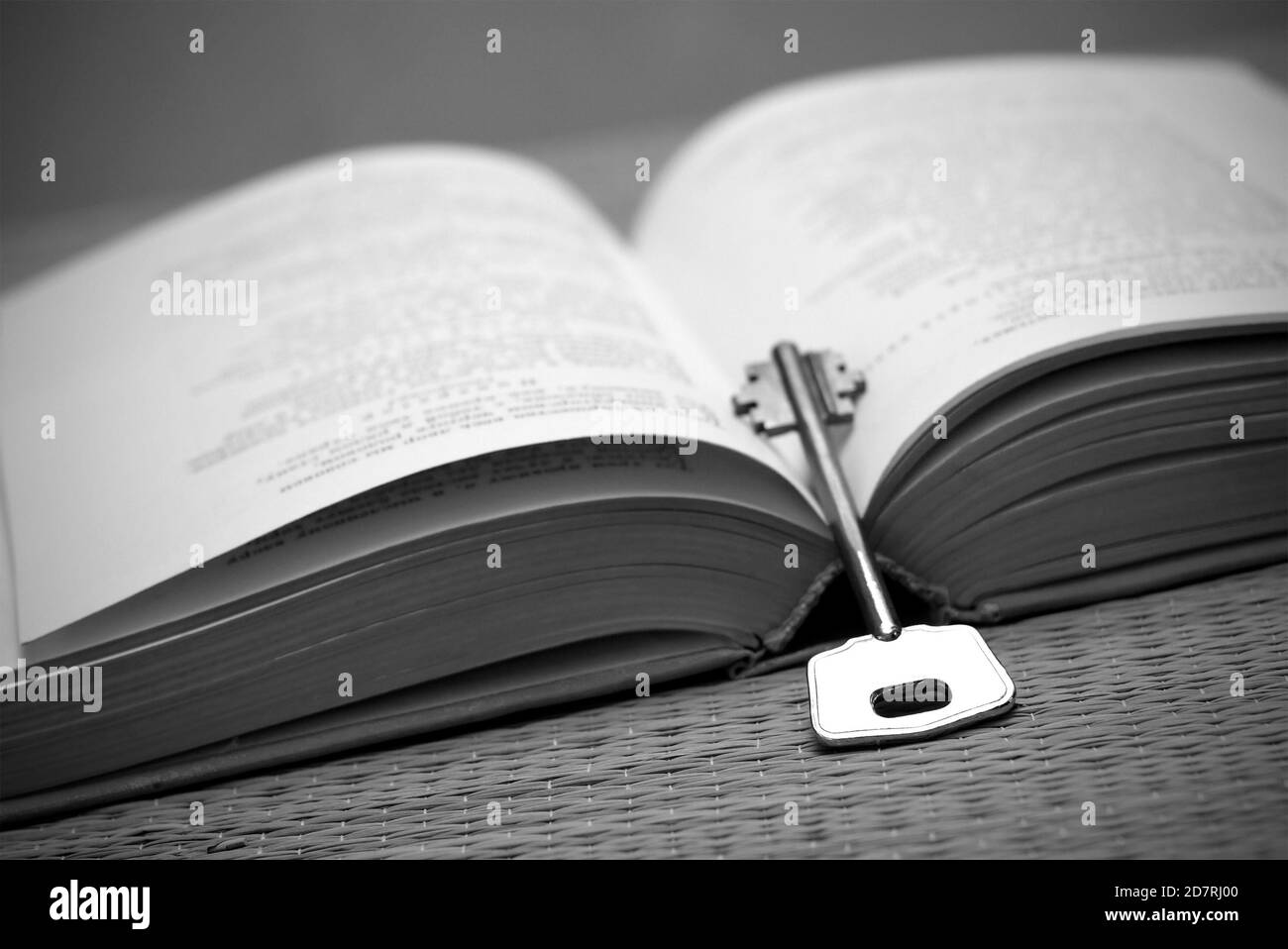 Un livre ouvert et une clé en noir et blanc. Banque D'Images