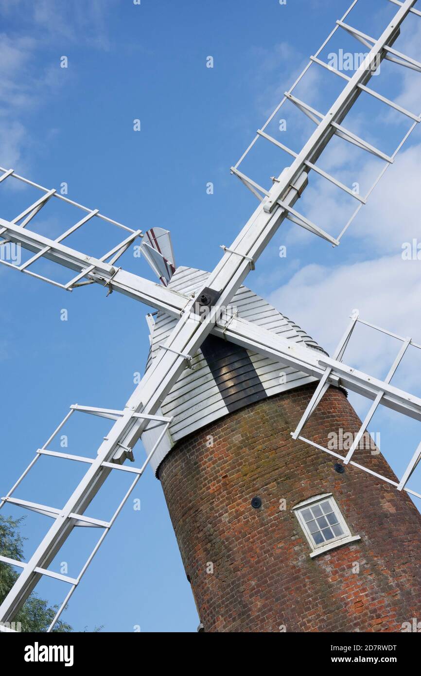 Gros plan sur le sommet d'une pompe à vent traditionnelle (moulin à vent) : voiles blanches et revêtement en bois au sommet d'un bâtiment en brique Banque D'Images