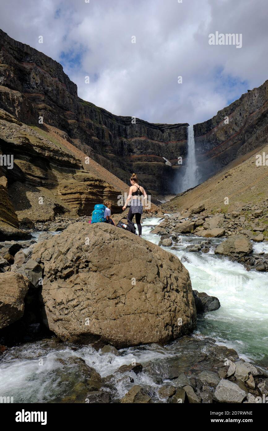 Randonneurs touristiques appréciant la chute d'eau Hengifoss et la rivière Hengifossa à l' Le paysage des hautes terres de Fljótsdalshreppur est de l'Islande Banque D'Images