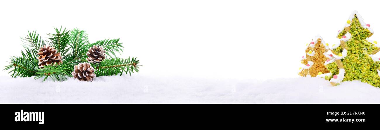 Branches de sapin de Noël avec arbres de cookie sur neige isolée sur Fond blanc - Panorama Banque D'Images
