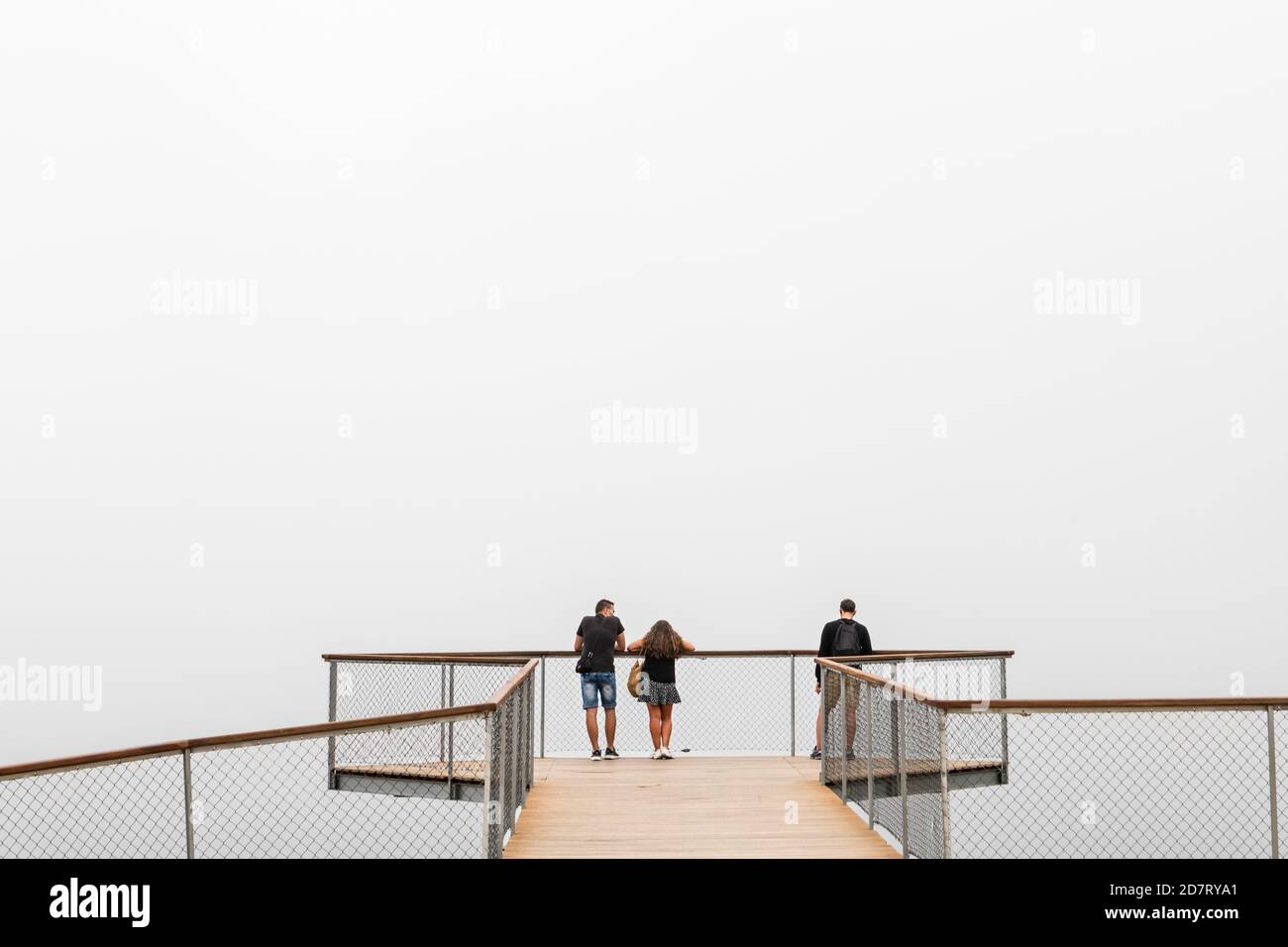 PONTEVEDRA, ESPAGNE - 25 AOÛT 2020 : un petit groupe de personnes attend que le brouillard s'élève sur un point de vue moderne sur l'estuaire de la Ria de Arousa en Galice. Banque D'Images