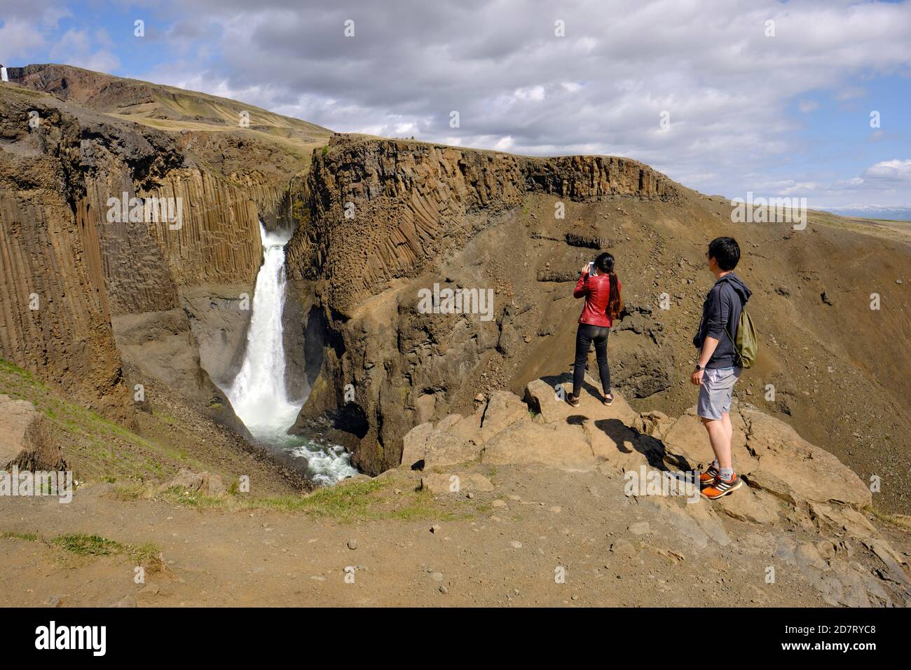 Les touristes prenant des photos sur leurs appareils mobiles à la cascade de Litlanesfoss Dans l'est de l'Islande - tourisme Islande Banque D'Images