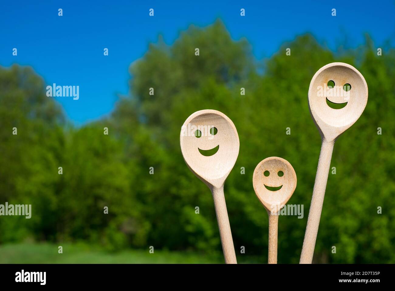 Les cuillères en bois ressemblent à une famille heureuse. Visages souriants. Banque D'Images