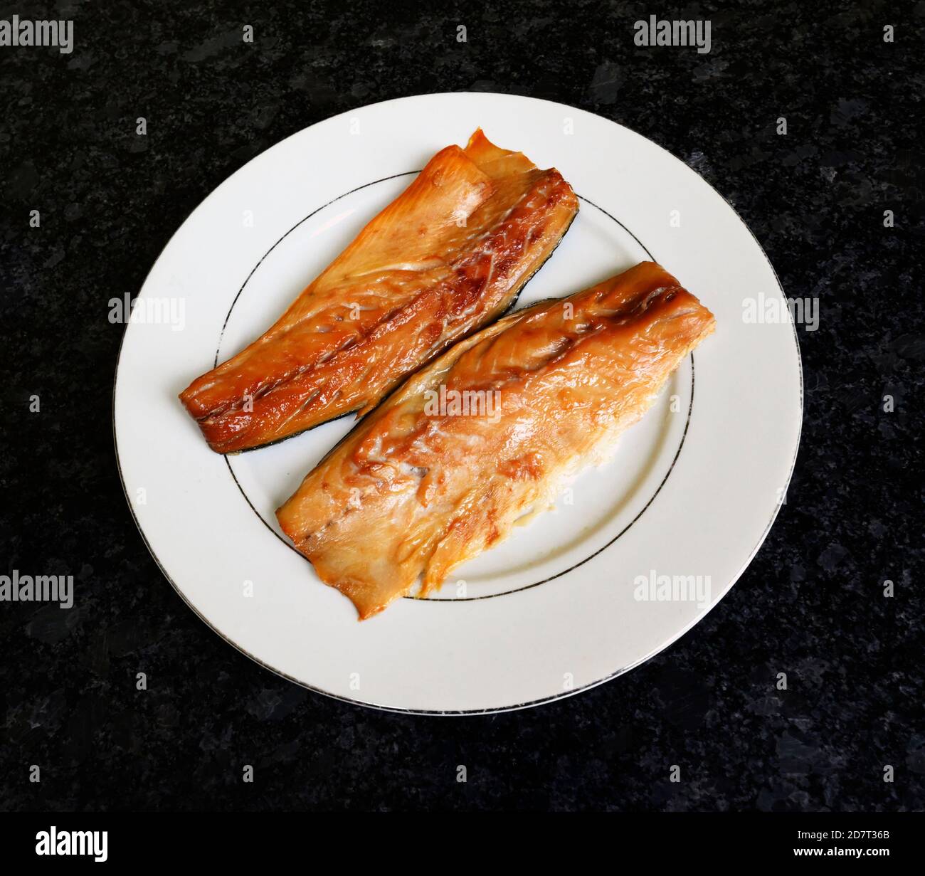 Deux filets de maquereau fumé sur une assiette blanche. Banque D'Images