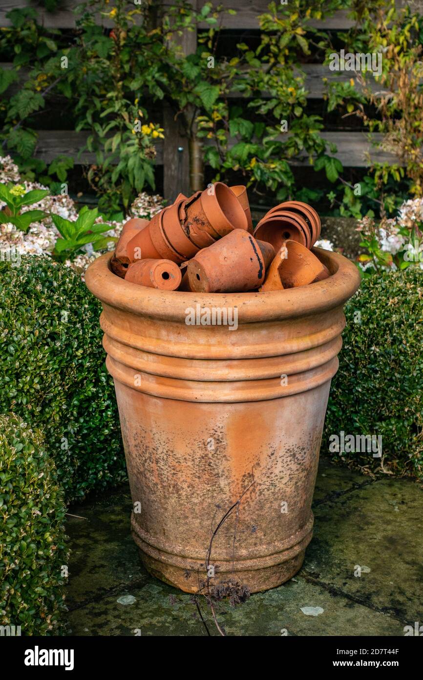 Très grand pot de terre cuite avec beaucoup de petite terre cuite pots de plantes dans un jardin Banque D'Images