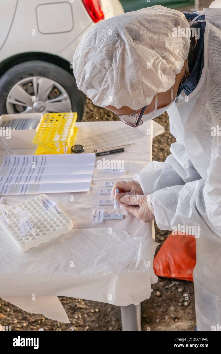 Un technicien de laboratoire effectue un test rapide Covid-19 avec un dispositif qui donne le résultat immédiatement, dans un trajet situé dans une rue de ville, E Banque D'Images