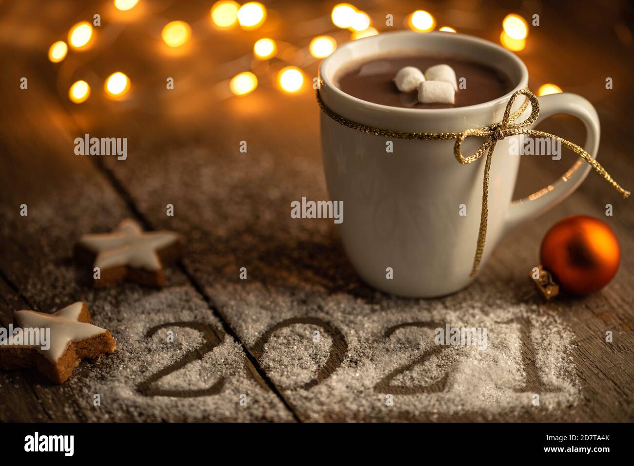 Jahreswechsel 2020/21 - Weihnachtliche Szene mit Zimtsternen, heißem Kakao, Lichtern und Jahreszahl 2021 auf Holz Banque D'Images