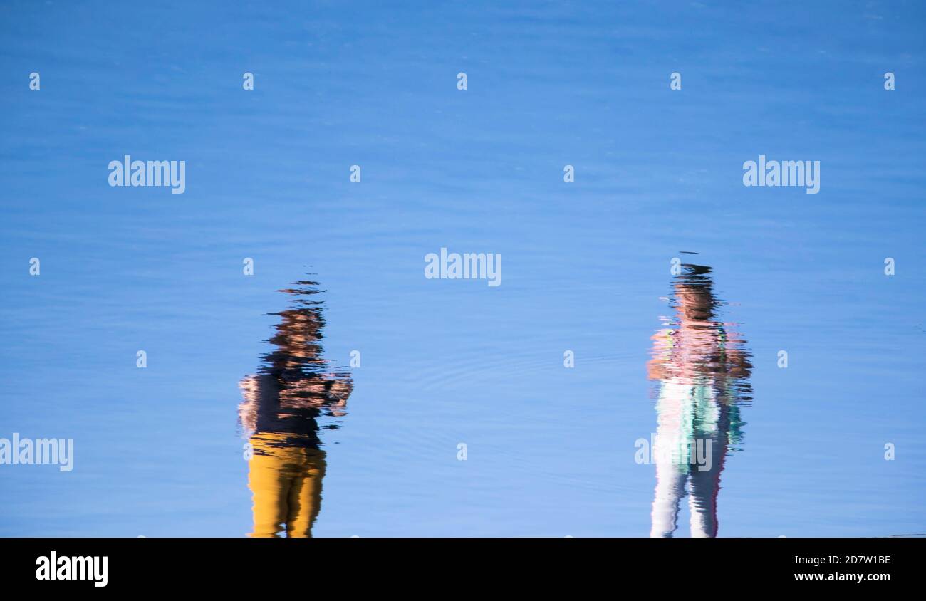 Reflet de deux jeunes femmes debout, dans un lac d'eau, par un jour ensoleillé Banque D'Images