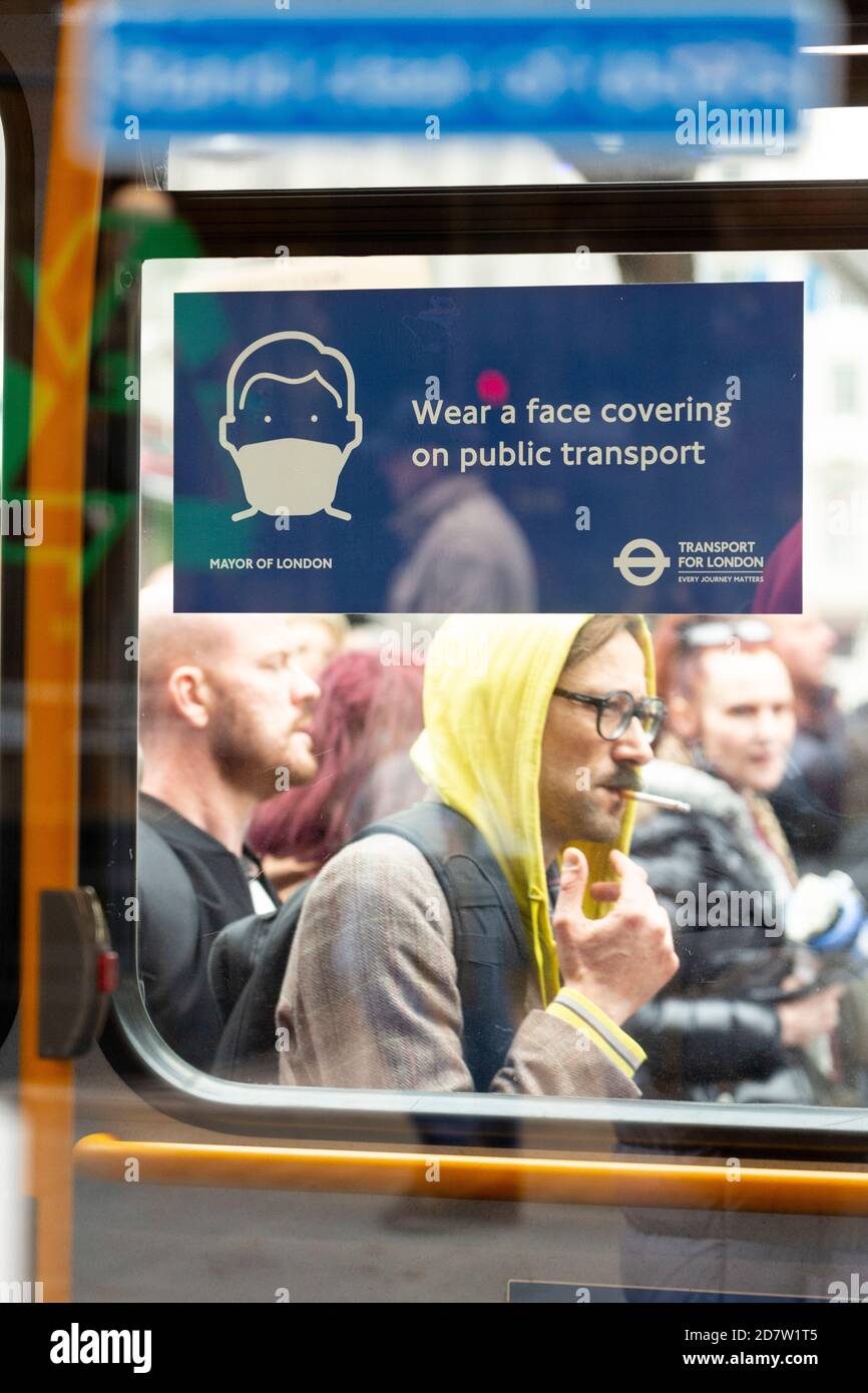 Les manifestants ont passé les instructions de la COVID-19 sur une fenêtre de bus lors d'un rassemblement anti-verrouillage à Londres, le 24 octobre 2020 Banque D'Images