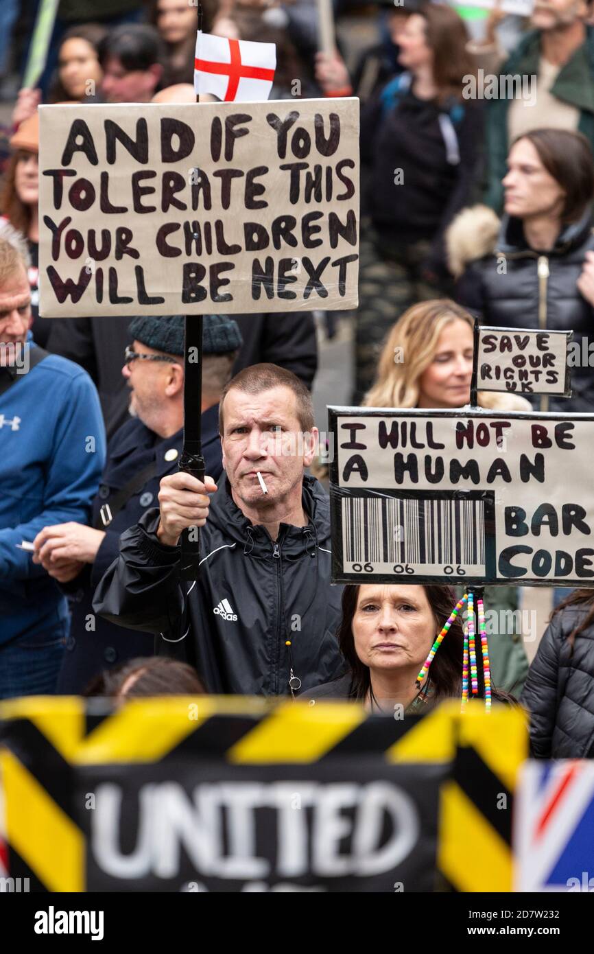 Des manifestants font des signes auprès de la foule lors d'un rassemblement anti-verrouillage à Londres, le 24 octobre 2020 Banque D'Images