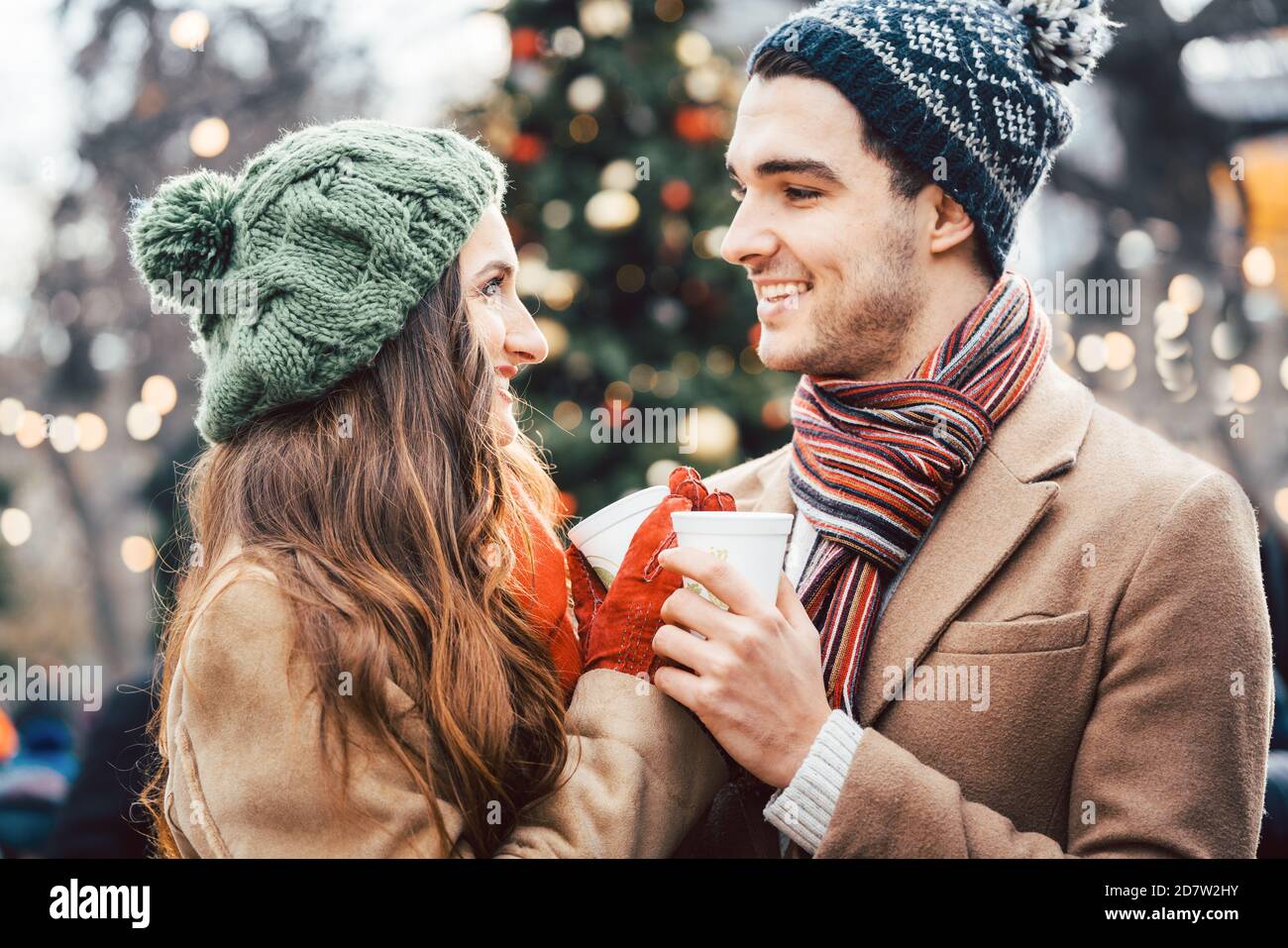 La femme et l'homme de boire du vin chaud sur le marché de Noël Banque D'Images