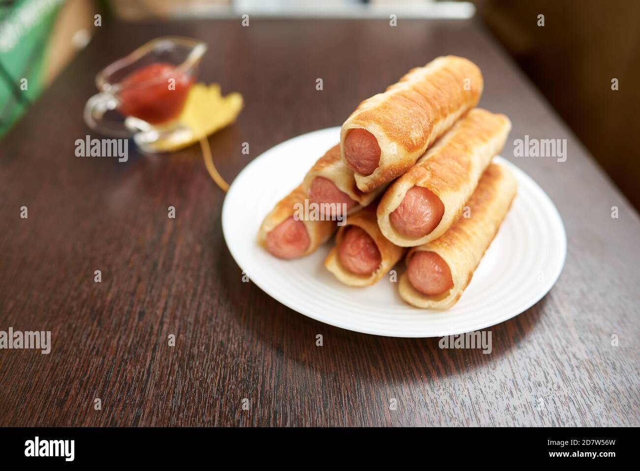 Saucisses dans de la pâte rôtie. Tartes frites avec saucisses. Ils sont enveloppés dans de fines bandes de pâte au beurre. Banque D'Images