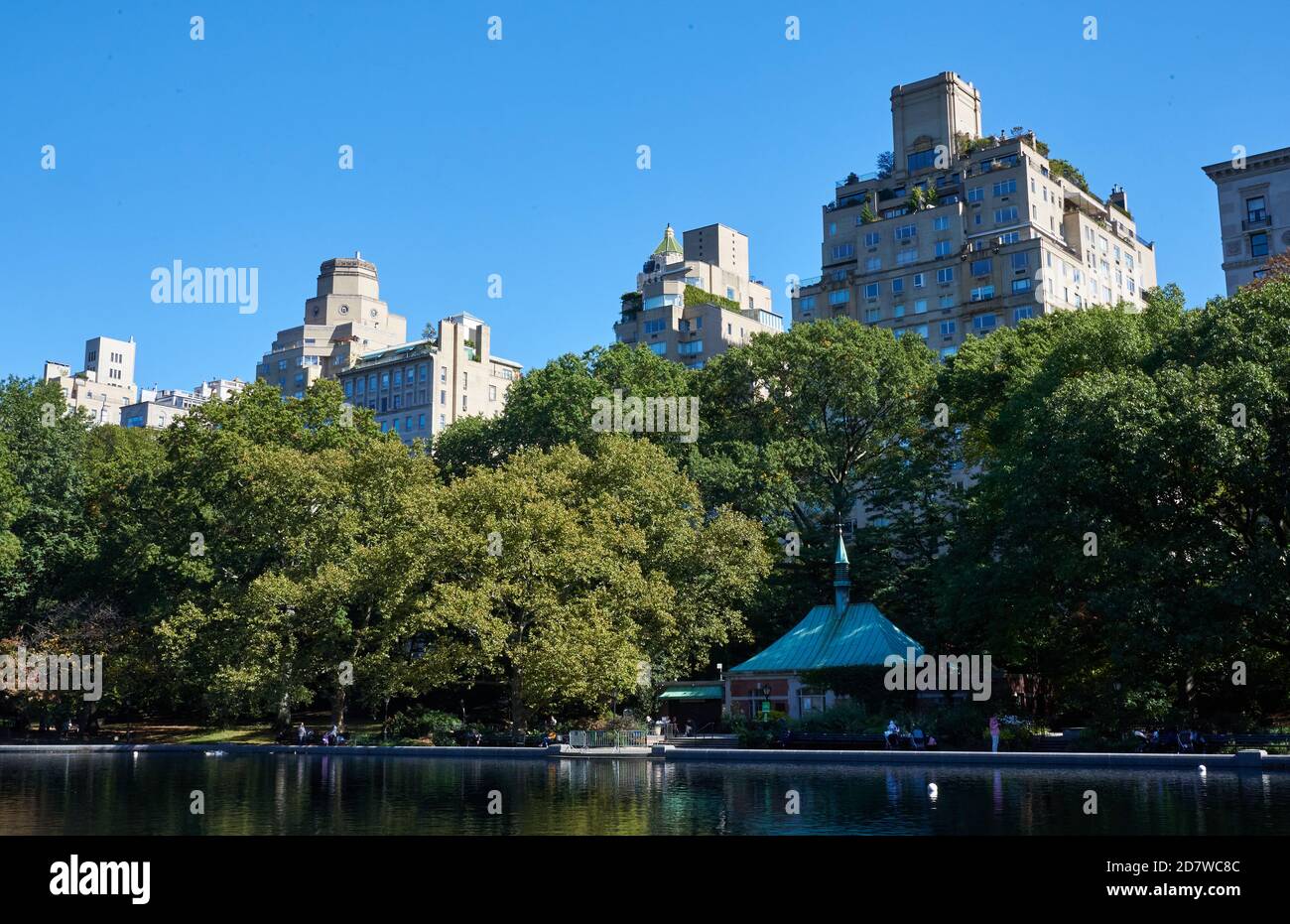Conservatory Water est un modèle d'étang de bateau dans Central Park à Manhattan, New York City. Au-delà des arbres se trouvent des immeubles d'appartements sur la Cinquième Avenue Banque D'Images