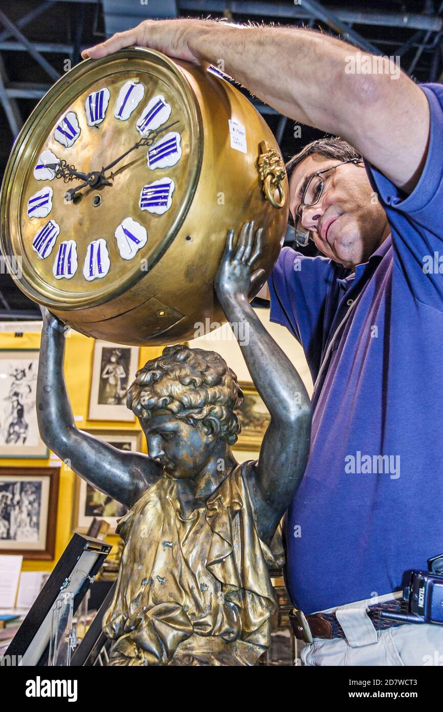 Florida,Miami Beach Convention Center,centre,Antique Show commerçant homme examine examiner, regarde Renaissance Revival banque horloge construit 188 Banque D'Images
