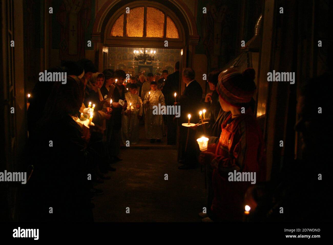 Service de Pâques en soirée dans une église chrétienne orthodoxe en Roumanie. Croyants tenant le feu Saint célébrant la Résurrection du Christ. Banque D'Images