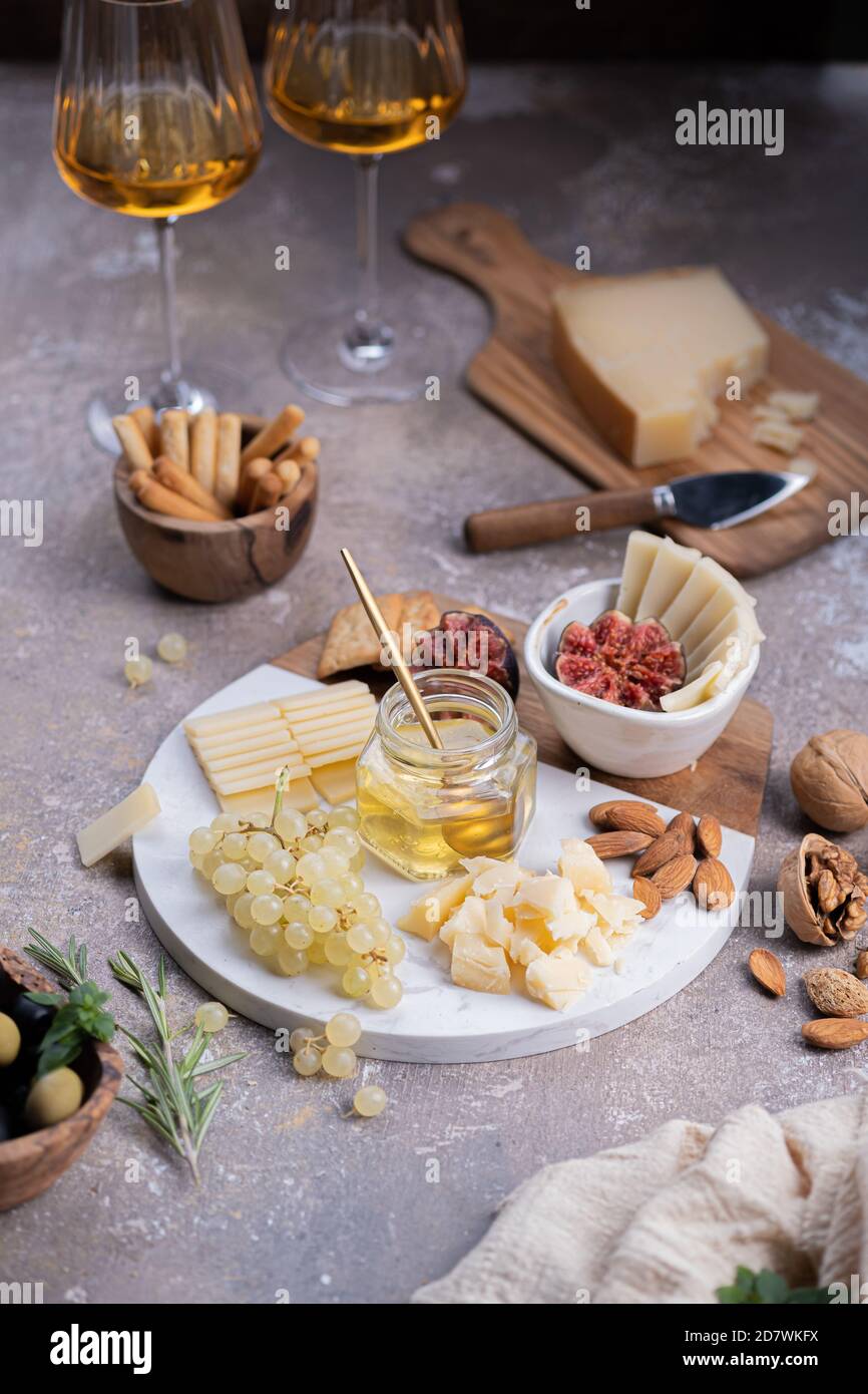 Assortiment de fromages sur plaque de marbre avec figues, noix, raisins et miel Banque D'Images