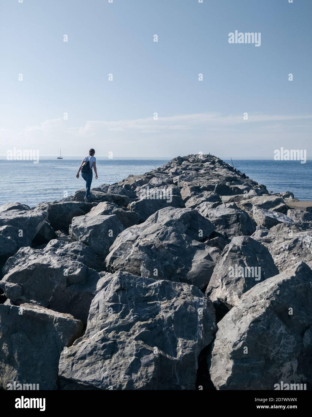 Femme marchant sur des rochers, allant vers l'eau Banque D'Images