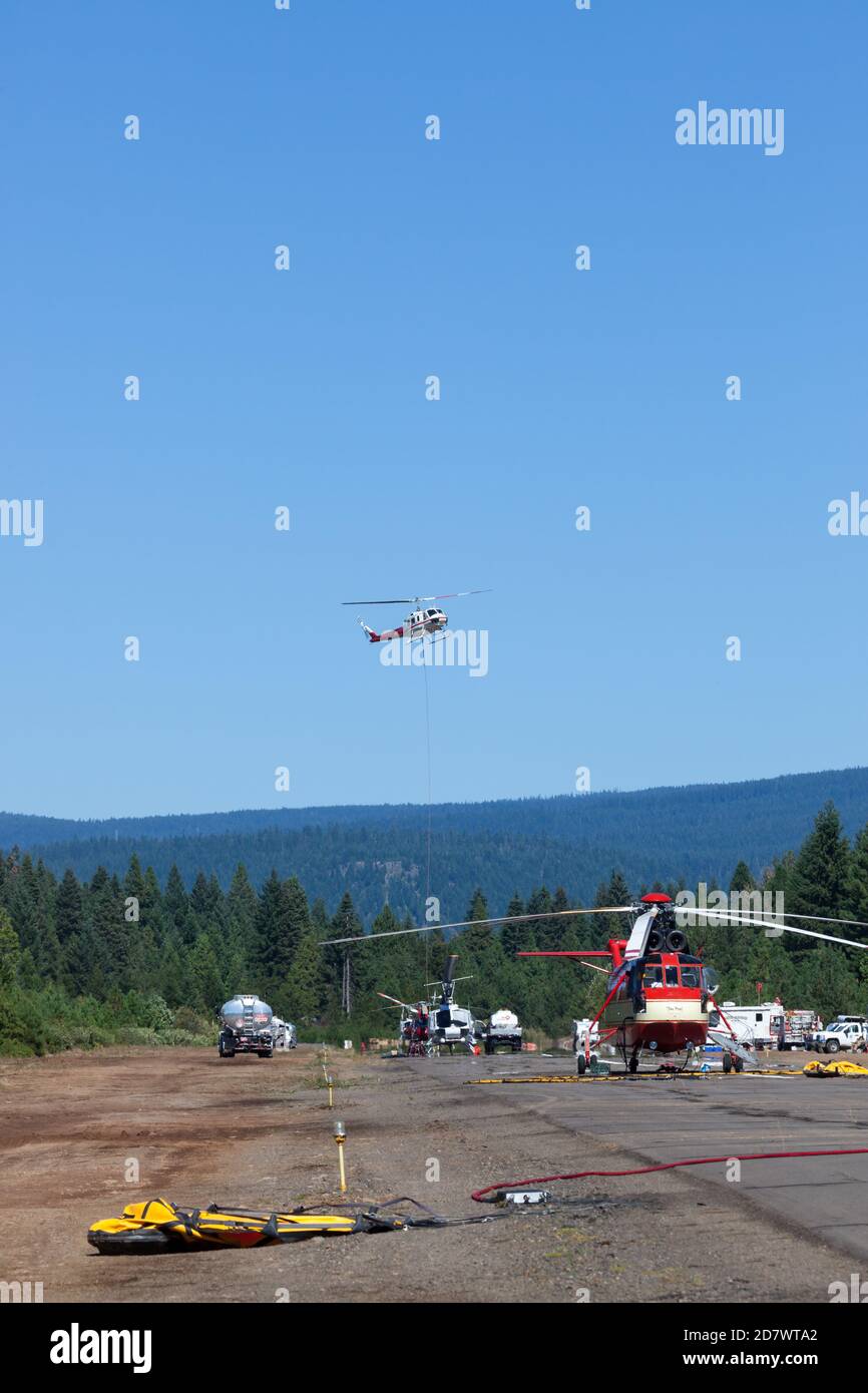 Prospect, Oregon / États-Unis - 9 septembre 2014 : un grand hélicoptère nommé « le Pres » sur la piste et un plus petit dans l'air qui part pour combattre le 790 Banque D'Images
