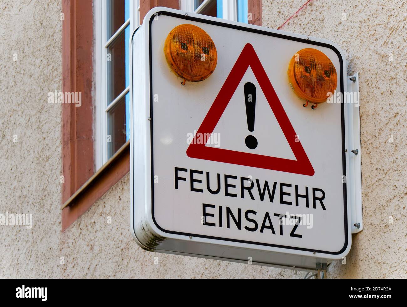 Panneau sur une façade indiquant que les voyants d'alerte jaunes clignotent lorsque les pompiers sont en action. Mit Warnleuchten für Feuerwehr Banque D'Images