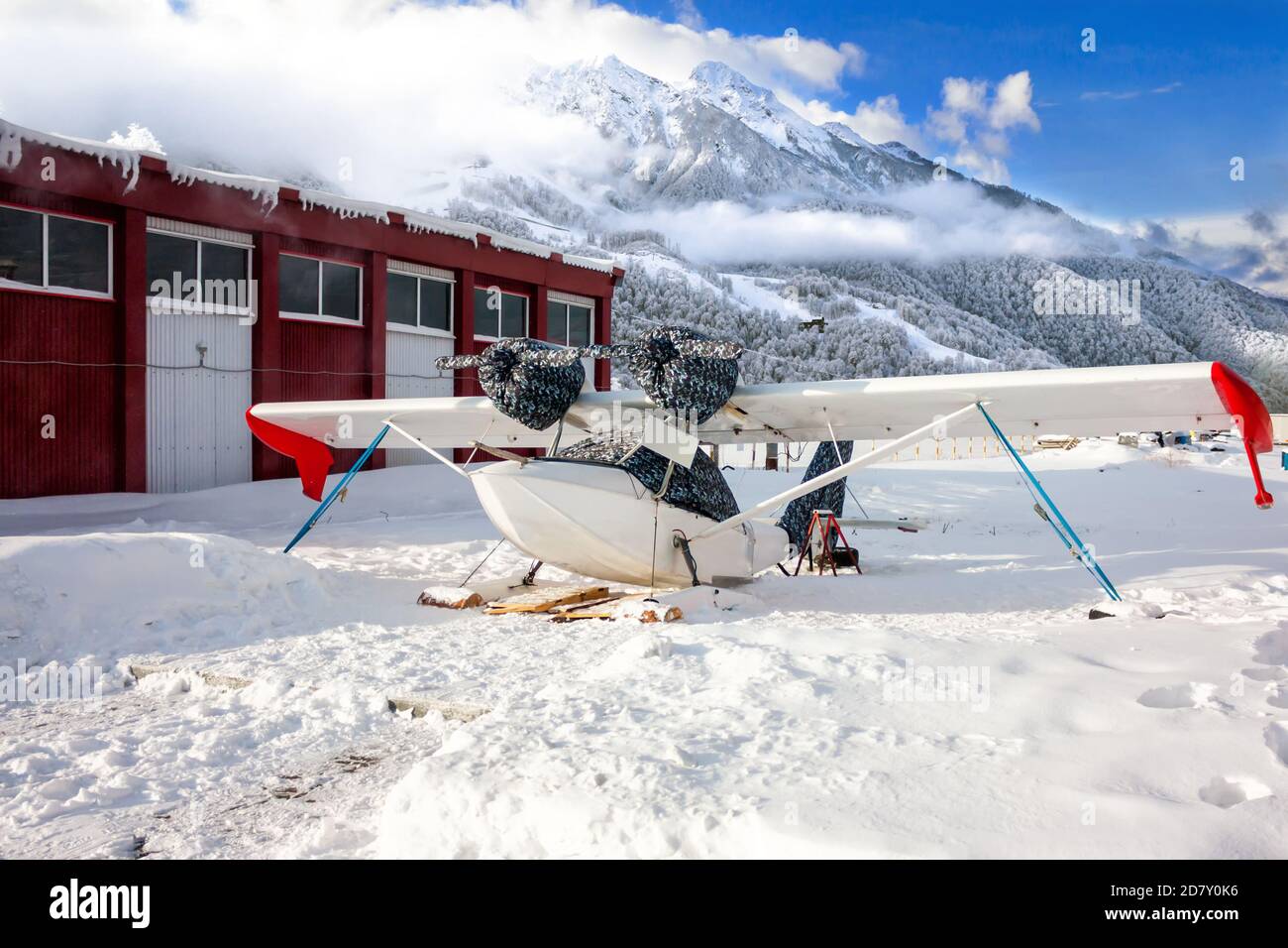 Hydravion blanc de sauvetage sur le train d'atterrissage de ski en hiver montagnes Banque D'Images