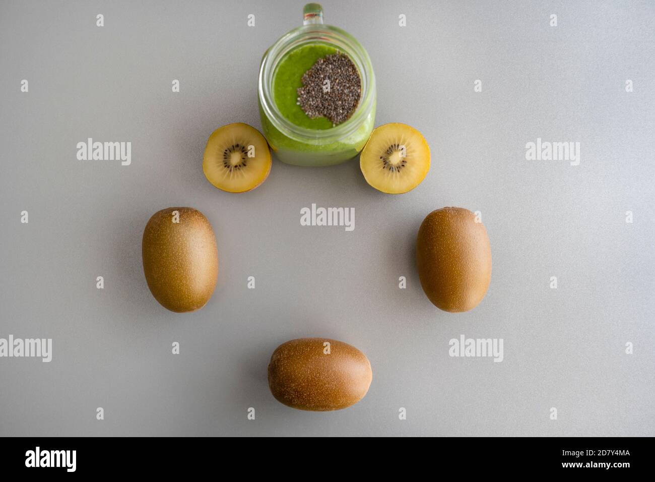 Smoothie au kiwi vert avec chia dans un pot de mason sur fond gris avec kiwis.nourriture saine , avec épinards, ananas, kiwi et raisins.concept de la nourriture créative Banque D'Images Smoothie au kiwi vert avec chia dans un pot de mason sur fond gris avec kiwis.nourriture saine , avec épinards, ananas, kiwi et raisins.concept de la nourriture créative Banque D'Images